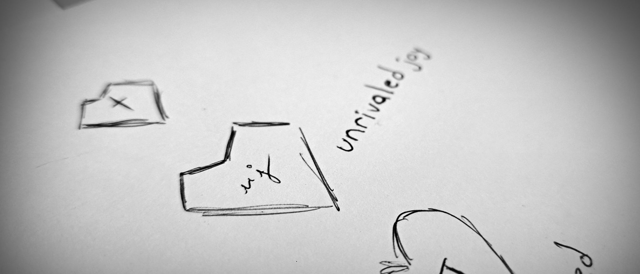 unrivaled joy logo pen sketches on white paper